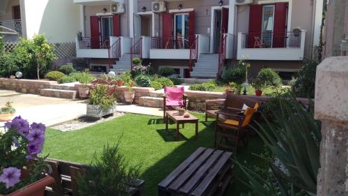 a garden with chairs and a bench in front of a building at Victoria Studios in Panagioúda