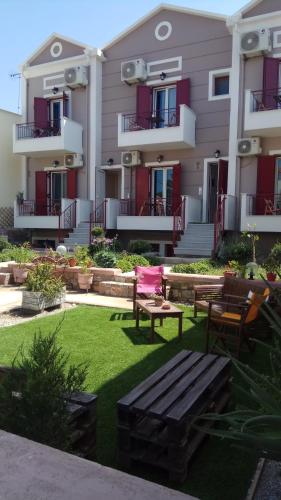 a yard with a bench in front of a building at Victoria Studios in Panagioúda