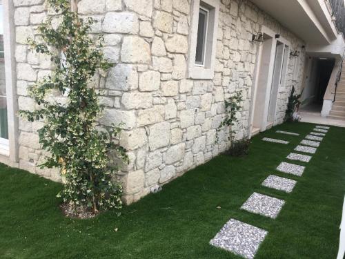 a building with a stone wall with a plant next to it at Grand Alaçatı Butik Hotel in Alacati
