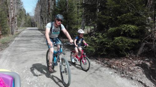 a man and a child riding bikes on a road at Haus Maria in Kleinarl