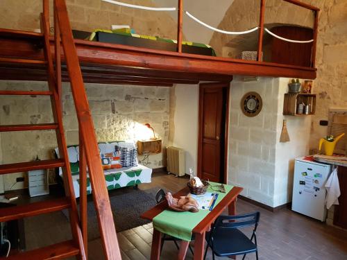 トラーニにあるGuesthouse A Casina b&bの二段ベッド1組、テーブル、キッチンが備わる客室です。
