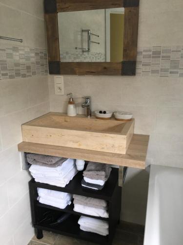 a bathroom with a wooden sink and towels at Maison du golf in Nieuwpoort