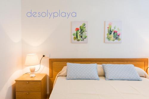 een slaapkamer met een bed en drie schilderijen aan de muur bij desolyplaya Galicia in Oropesa del Mar