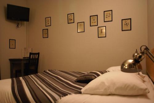 a bedroom with a bed with pictures on the wall at Hotel de la Placette Barcelonnette in Barcelonnette