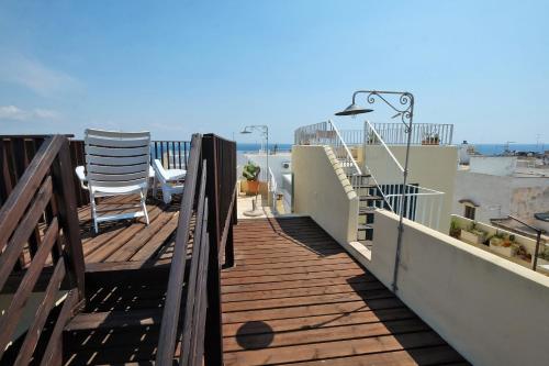 a wooden deck with a chair on a balcony at Casa Nelly in Gallipoli