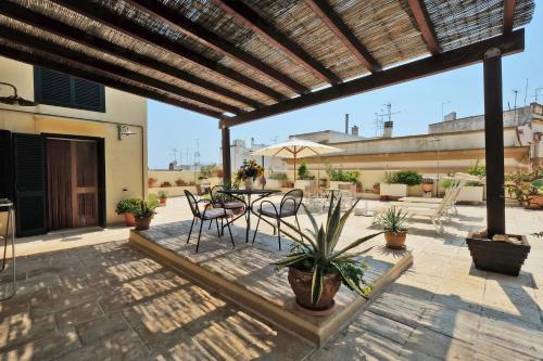 a patio with a table and chairs and an umbrella at Casa Nelly in Gallipoli