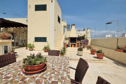 a patio with a table with chairs and potted plants at Casa Nelly in Gallipoli