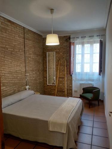 バレンシアにあるApartamento con estiloのベッドルーム(大型ベッド1台、椅子付)