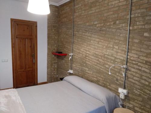 a bed in a room with a brick wall at Apartamento con estilo in Valencia