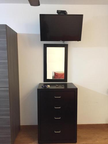 a black dresser with a mirror on a wall at Habitaciones amuebladas Veracruz Logos in Veracruz