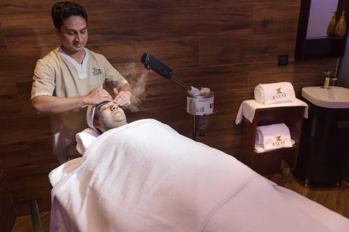 a man in a hospital room getting his hair cut at Bayat Hotel in Khamis Mushayt