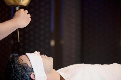 a man laying in bed with his head on a towel at Bayat Hotel in Khamis Mushayt