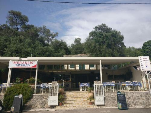 a restaurant with tables and chairs in front of a building at Stavroula Studios in Paleokastritsa