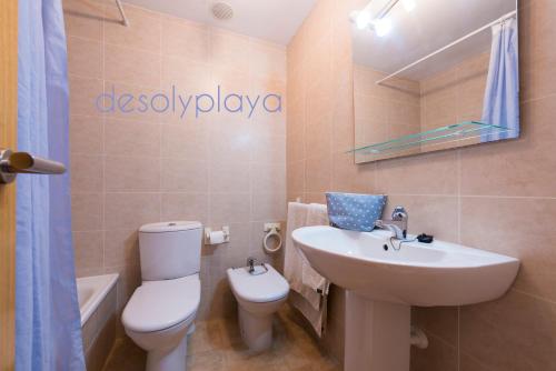 a bathroom with a sink and a toilet and a mirror at desolyplaya Colomeras 2J in Oropesa del Mar