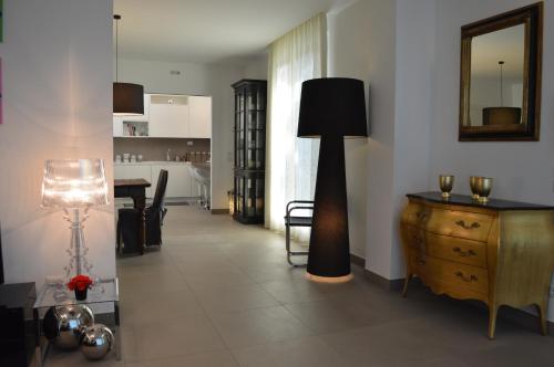 a living room with a floor lamp and a dresser at Maison Margot in Acquaviva Picena