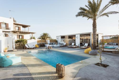 a villa with a swimming pool and palm trees at White and Grey in Mikonos