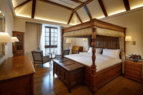 a bedroom with a canopy bed with a desk in it at Lotte Arai Resort in Myoko