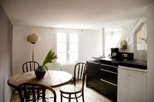 uma cozinha com uma mesa e cadeiras numa cozinha em Appartements Au-Dessus Du... em Estrasburgo