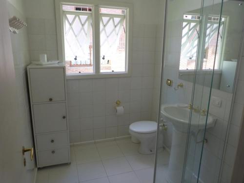 Casarao Do Bavaria في غرامادو: حمام ابيض مع مرحاض ومغسلة