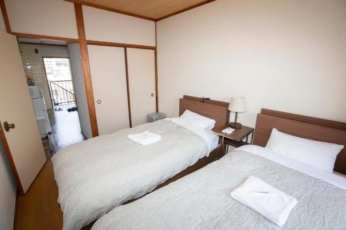 2 łóżka w małym pokoju z: w obiekcie Lazy House w mieście Okayama