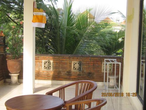 a table and chairs on a balcony with plants at Purnama di Bisma in Ubud