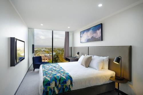 a hotel room with a bed and a large window at Mantra Albury in Albury