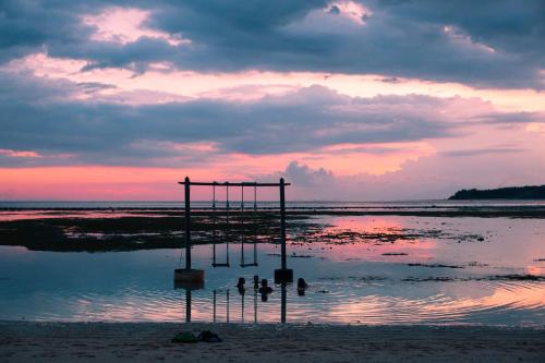 a group of people standing in the water on a beach at Island View Bar & Bungalow in Gili Air