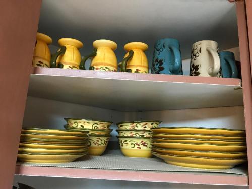 a shelf with different colored bowls and plates at Gonzales Cozy Little Bear Cabin in Ruidoso