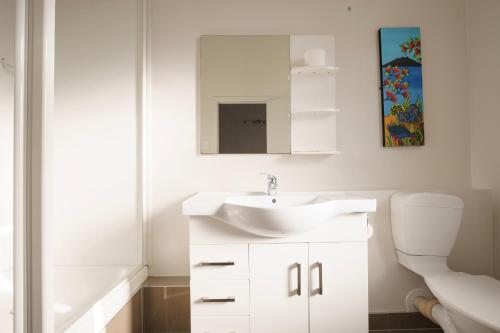 Baño blanco con lavabo y aseo en Kiwi International Hotel en Auckland
