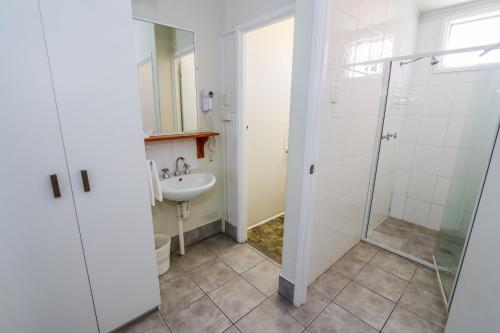 ein Bad mit einer Dusche und einem Waschbecken in der Unterkunft Miriam Vale Motel in Miriam Vale