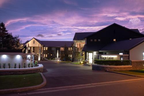 a night view of a house with a driveway at Village Lake Luxury Apartments in Hanmer Springs