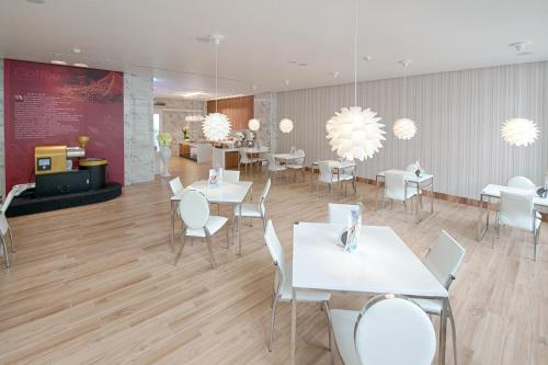 a restaurant with white tables and chairs and chandeliers at Six Star Motel-Taoyuan in Taoyuan