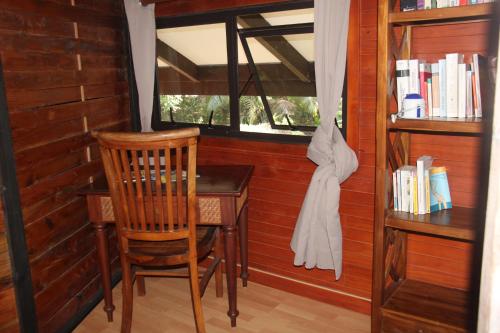 a desk and chair in a room with a window at Haere Mai I Te Fare in Teavaro