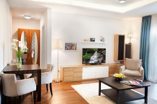 a living room with a dining table and a television at A Blok-Apartment The One in Belgrade