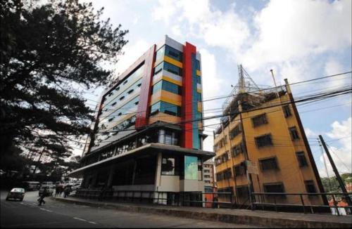een hoog gebouw aan de kant van een stadsstraat bij Hotel 45 Extension in Baguio