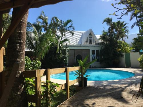 a house with a swimming pool in front of a house at La Rose du Sud in Saint-Joseph