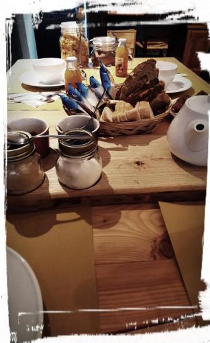 a table with bread and jars of food on it at Lu Garun Rus in Valdieri