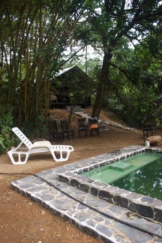 a pool with a lounge chair and a table and a pool at Los Mineros Guesthouse in Dos Brazos