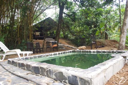 a swimming pool with a stone wall around it at Los Mineros Guesthouse in Dos Brazos