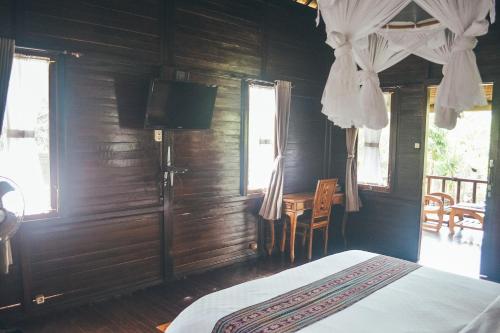 - une chambre avec un lit, une table et des fenêtres dans l'établissement Kubu Alas Tunggal Villa, à Sidemen