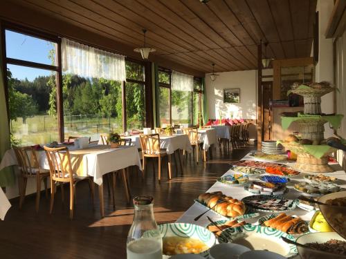 ein Esszimmer mit Tischen und Teller mit Lebensmitteln in der Unterkunft Landhotel Gasthof Eichhof Natters in Innsbruck