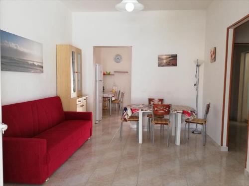 sala de estar con sofá rojo y mesa en Alvaro Holiday Home, en Torre Lapillo