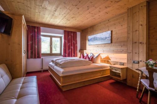 a bedroom with a bed in a room with wooden walls at Pension Hüttwirt in Kössen