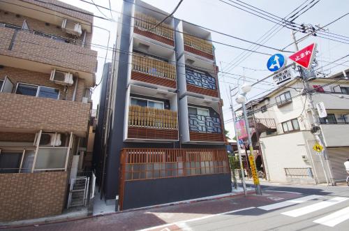 a building on the corner of a city street at Numero Uno Tokyo in Tokyo