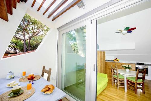a kitchen and dining room with a glass door leading to a dining table at Lara Elite in Castiglione della Pescaia