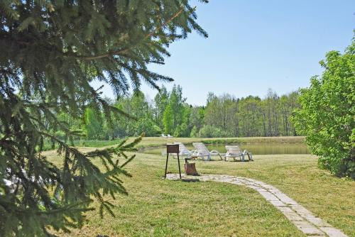 two chairs sitting in a park next to a lake at Kliukai in Dubingiai