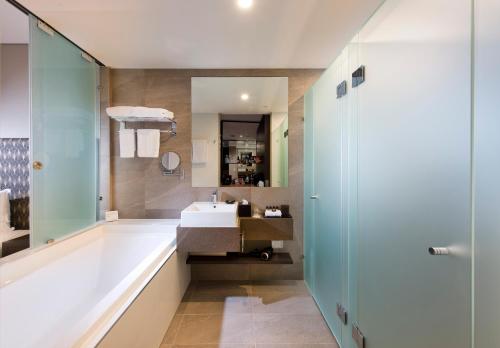 a bathroom with a sink and a shower at Pullman Brisbane Airport in Brisbane