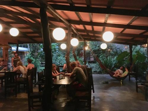 a group of people sitting at a table in a restaurant at Los Mineros Guesthouse in Dos Brazos