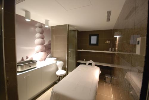 a small bathroom with a bed and a sink at Migjorn Ibiza Suites & Spa in Playa d'en Bossa