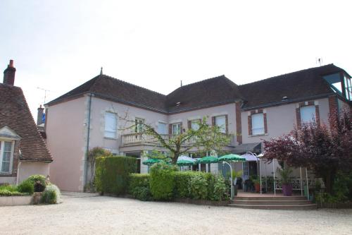 a large white house with umbrellas in front of it at Blanche de Castille in Bléneau